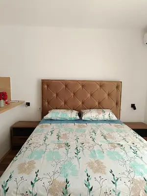 a bedroom with a bed with a bedspread and pillows at Apartmani Maša in Budva