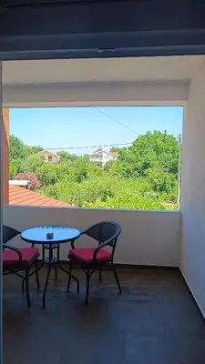 a room with a table and chairs and a large window at Apartmani Maša in Budva