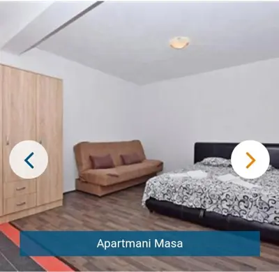 a bedroom with a bed and a chair at Apartmani Maša in Budva