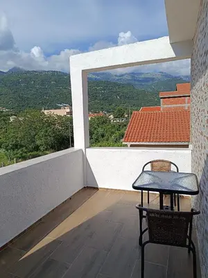 a balcony with a table and a view of the mountains at Apartmani Maša in Budva