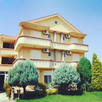 a large building with trees in front of it at Mali Medved Ulcinj in Ulcinj