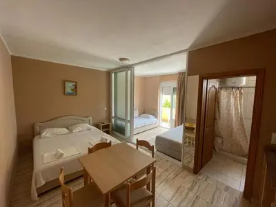 a bedroom with a bed and a table and a dining room at Mali Medved Ulcinj in Ulcinj