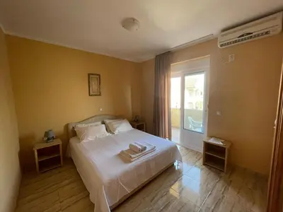a bedroom with a white bed and a balcony at Mali Medved Ulcinj in Ulcinj