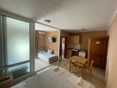 a room with a bed and a table and a kitchen at Mali Medved Ulcinj in Ulcinj
