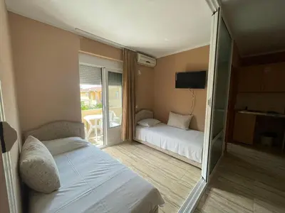 a hotel room with two beds and a balcony at Mali Medved Ulcinj in Ulcinj