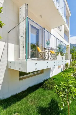 a balcony of a house with a table and chairs at The Luxury Maison W Nest - 2 bedroom apartment in Kotor