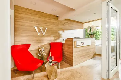 a dining room with red chairs and a table at The Luxury Maison W Nest - 2 bedroom apartment in Kotor