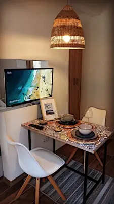 a room with a table with chairs and a television at Bonaca Apartments in Budva