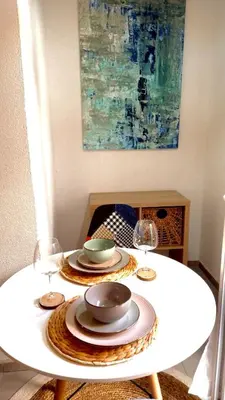 a white table with plates and wine glasses on it at Bonaca Apartments in Budva