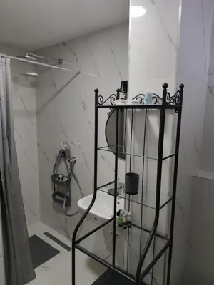 a bathroom with a glass shelf with a shower at Blue Apartment Riverside in Podgorica