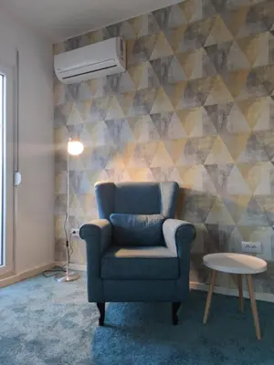 a living room with a blue chair and a table at Blue Apartment Riverside in Podgorica