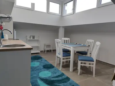 a kitchen and dining room with a table and chairs at Blue Apartment Riverside in Podgorica