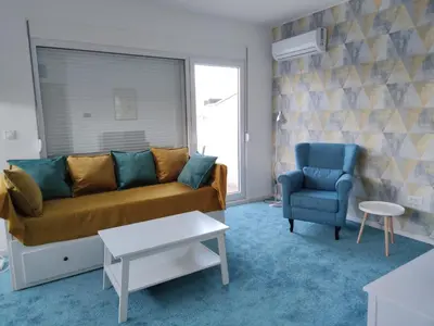 a living room with a couch and a chair at Blue Apartment Riverside in Podgorica