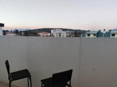 two chairs sitting on top of a white wall at Blue Apartment Riverside in Podgorica