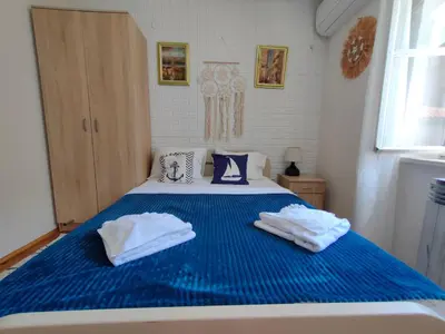 a blue and white bed with two towels on it at Beatrix Suites in Budva