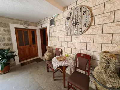 a room with a table and chairs and a clock on the wall at Beatrix Suites in Budva