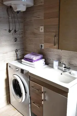 a bathroom with a washing machine and a sink at Sunset Apartments in Kotor