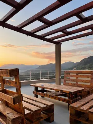 a deck with wooden benches and a view of the ocean at Sunset Apartments in Kotor