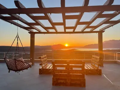a porch with a hammock and a view of the sunset at Sunset Apartments in Kotor
