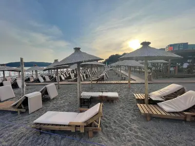 a group of lounge chairs and umbrellas on a beach at Apartment 