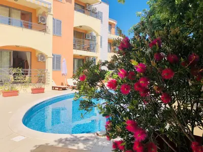 a villa with a swimming pool in front of a building at Apartment 