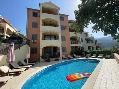 a hotel with a swimming pool in front of a building at Apartment 