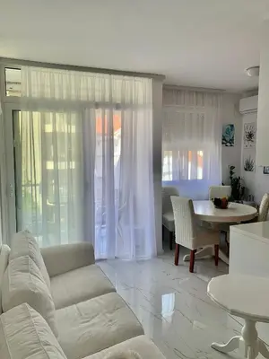 a living room with a white couch and a table at Apartment Lena, Budva Centar in Budva