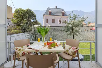 a table with a plate of fruit on a balcony at Ana's Place Near the Sea in Kotor