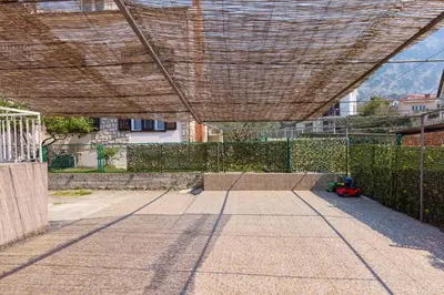 a patio with a fence and a wooden roof at Ana's Place Near the Sea in Kotor