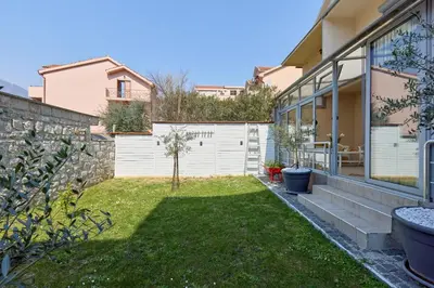 a backyard of a home with a white fence at Ana's Place Near the Sea in Kotor