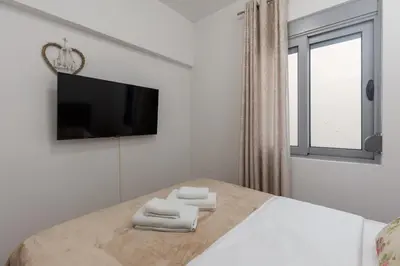 a white bedroom with a bed with two towels at Ana's Place Near the Sea in Kotor