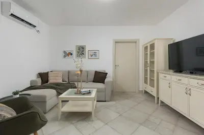 a living room with a couch and a tv at Ana's Place Near the Sea in Kotor