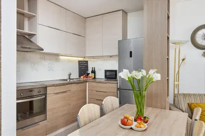 a kitchen with a table with a vase of flowers at Ana's Place Near the Sea in Kotor