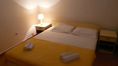 a bedroom with a bed with two towels on it at Guest house Živković in Sveti Stefan