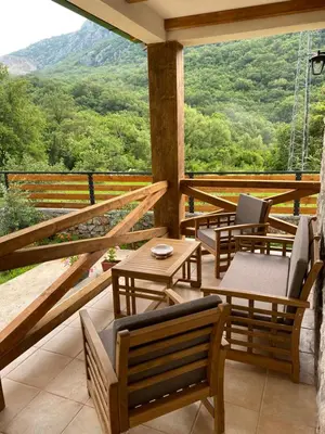 a porch with chairs and tables and a view of the mountains at Guest House Mare in Bar