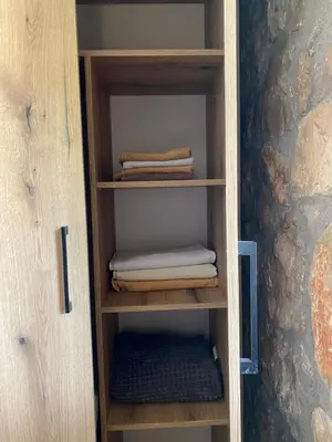 a wooden book shelf with folded towels in it at Guest House Mare in Bar