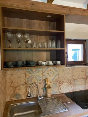 a kitchen with a sink and some glasses on the shelf at Guest House Mare in Bar