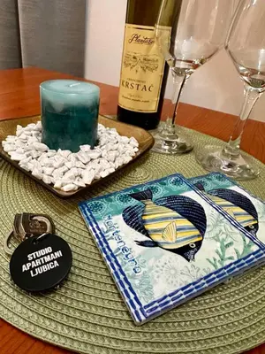 a table with a candle and a bottle of wine at Studio apartmani Ljubica in Budva