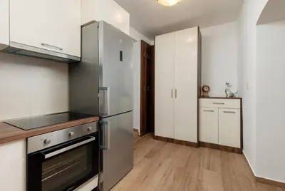 a kitchen with a stainless steel refrigerator and white cabinets at Apartment Amigo Old Town Kotor in Kotor
