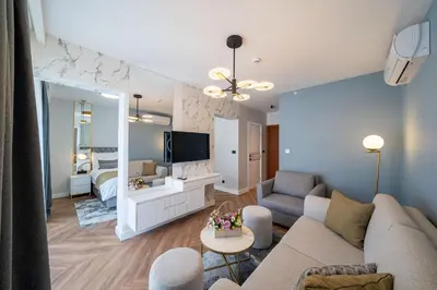 a living room with a couch and a tv in a room at Hotel Millennium by Aycon in Budva