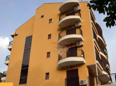 a yellow building with balconies on the side of it at Apartman Pejovic in Petrovac na Moru