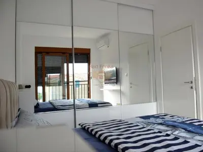 a bedroom with a mirror and a bed in it at Apartman Pejovic in Petrovac na Moru