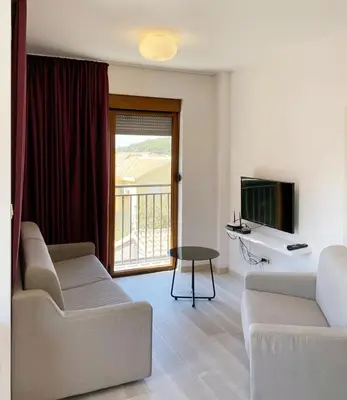 a living room with two couches and a television at Apartman Pejovic in Petrovac na Moru