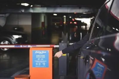 a man is reaching for a parking sign in a parking garage at Fontana Residence Budva in Budva