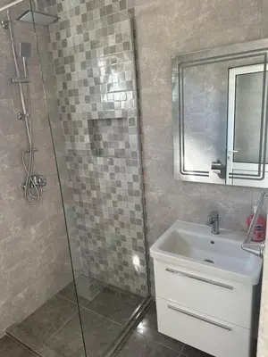 a bathroom with a shower and a sink and a mirror at Niki Apartments in Ulcinj