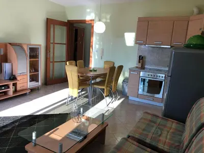 a kitchen and living room with a table and chairs at Stan Inlav Pržno in Pržno