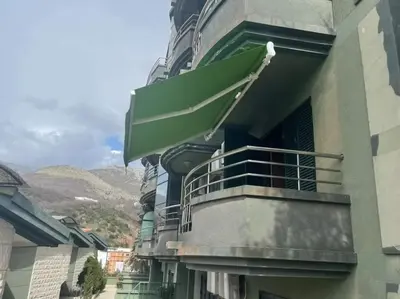 a balcony of a building with a green awning at Stan Inlav Pržno in Pržno