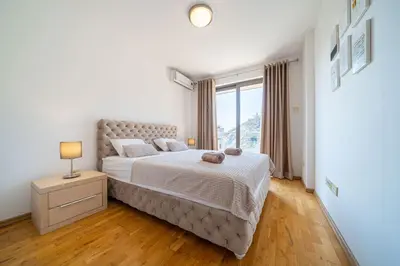 a bedroom with a large bed and a window at Luxury apartment near beach in Pržno