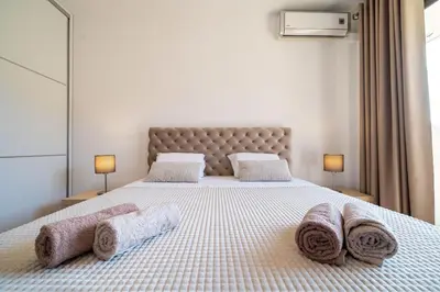 a bedroom with a bed with towels on it at Luxury apartment near beach in Pržno