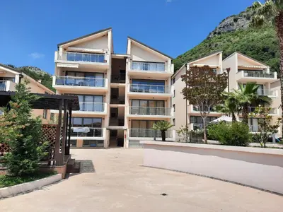 an apartment building in front of a mountain at Luxury apartment near beach in Pržno